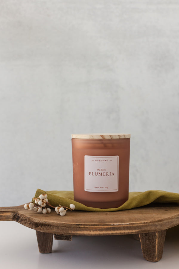 Hand-poured Plumeria soy candle with floral and peach notes in 10 oz jar