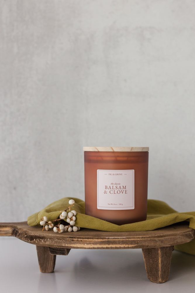 Balsam & Clove candle in brown glass jar with white berries evoking fresh mountain air and warm spice – Fig & Grove