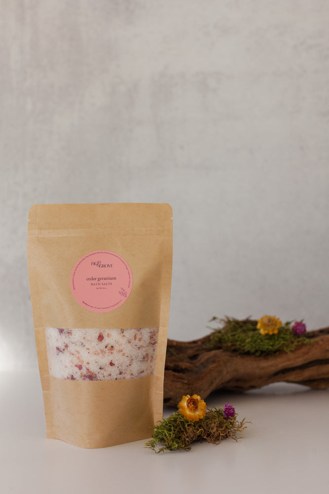 Cedar Geranium essential oil bath salts in a Kraft resealable pouch with a pink label on a neutral background - Fig & Grove